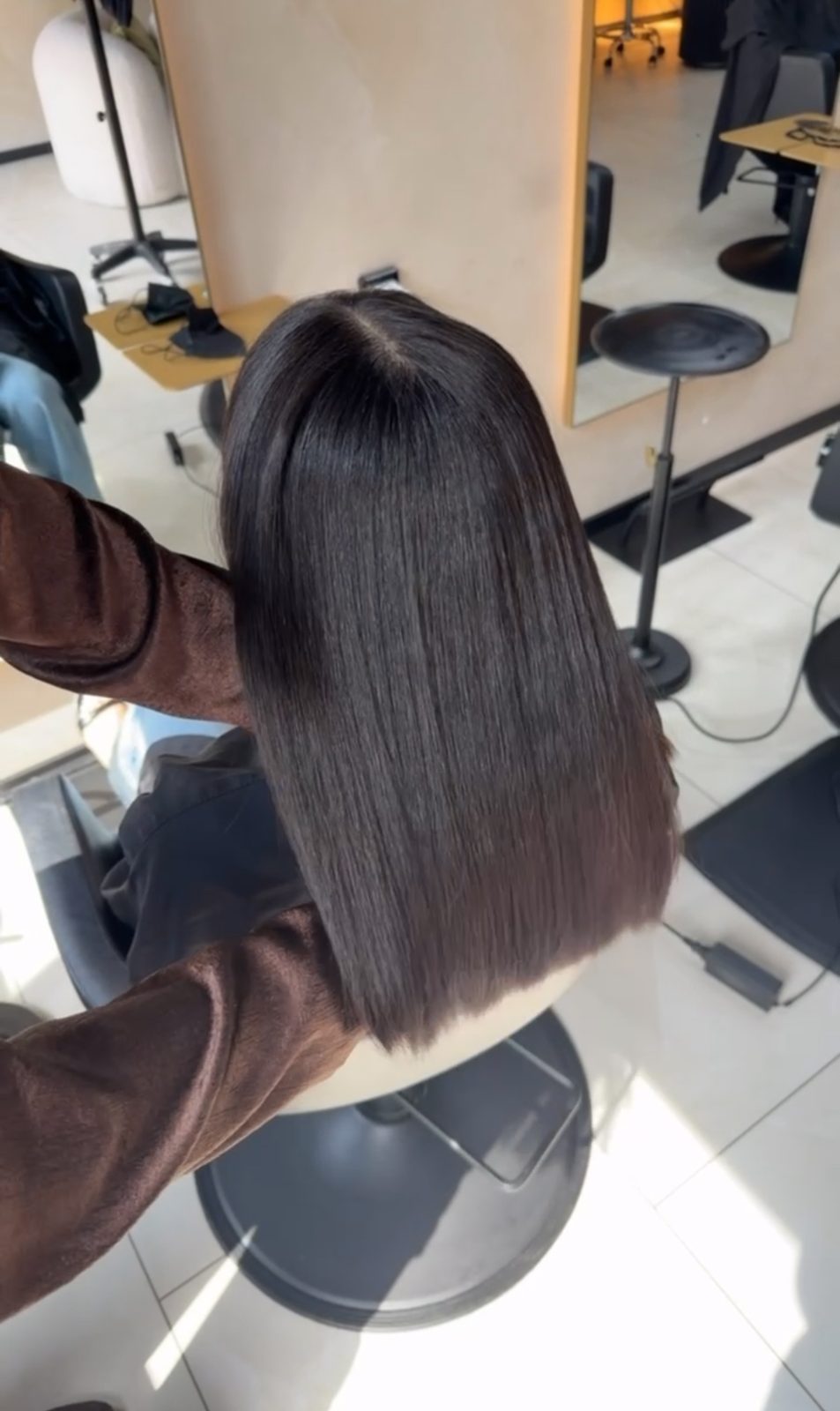 Een strak geföhnde bob wordt afgewerkt in de salon